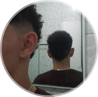 Wyllyan com camisa verde de corente, e com o rosto virado. Atrás dele uma parede na cor branca